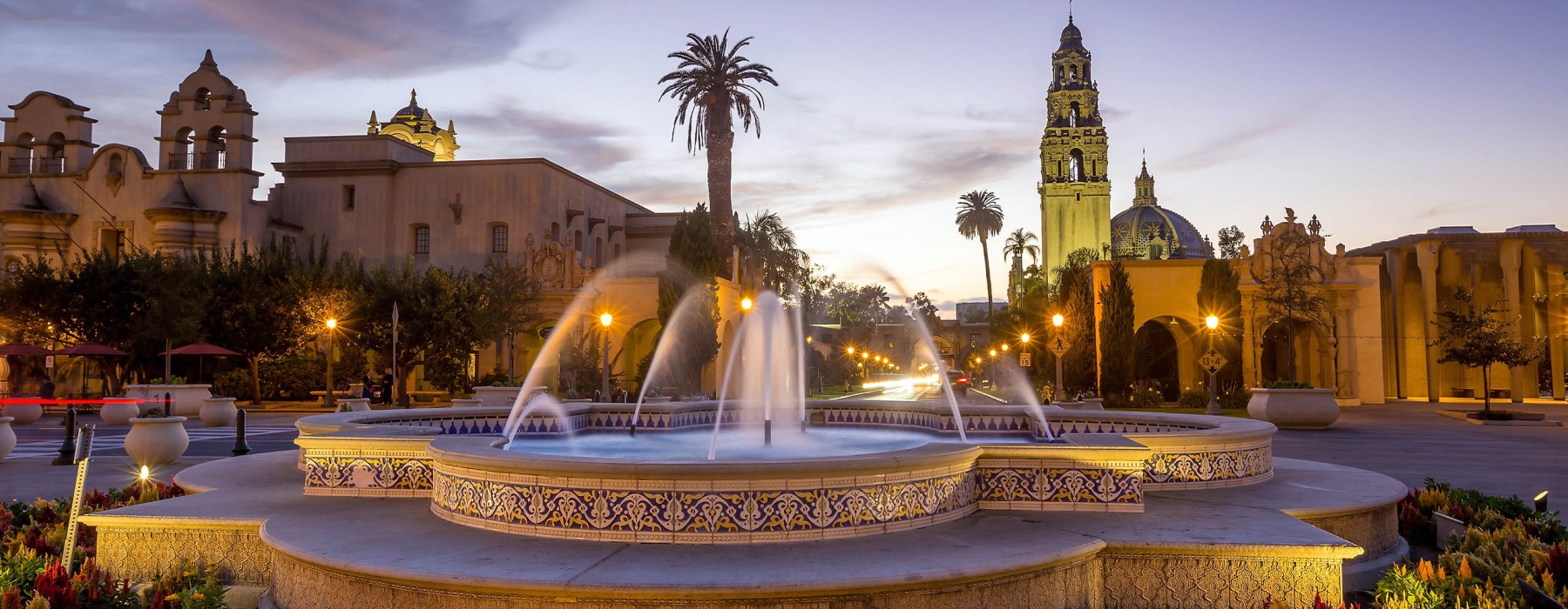 a fountain in a courtyard with buildings in the background